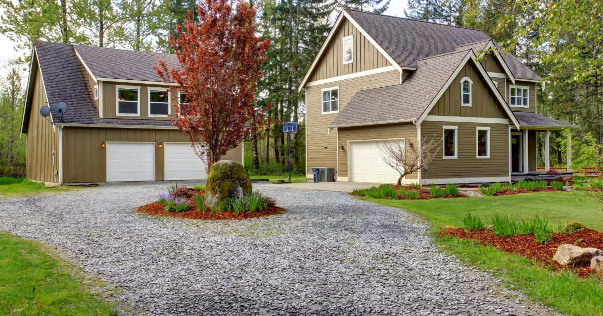 Gravel driveway repair example for a Hendersonville, NC home with landscaped yard and garage access.